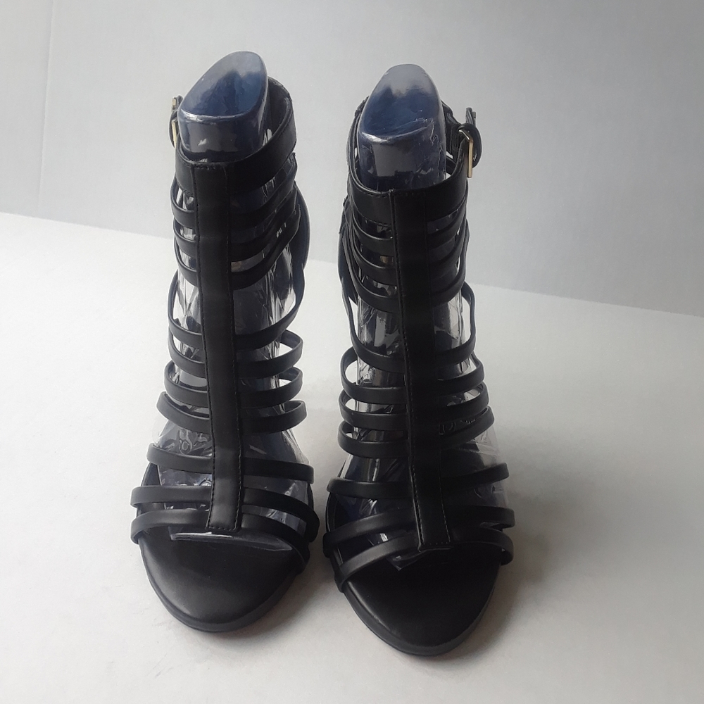 Black strapy heels with gold zippers.